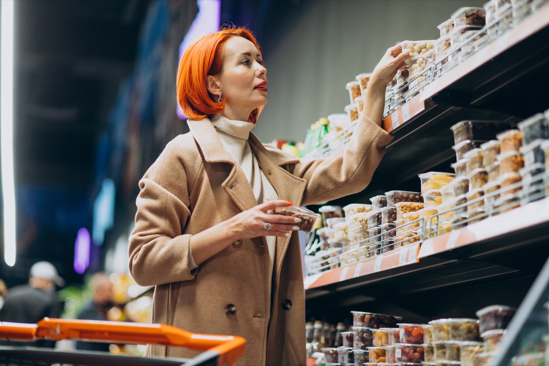 Kobieta wybierająca produkty z półek supermarketu